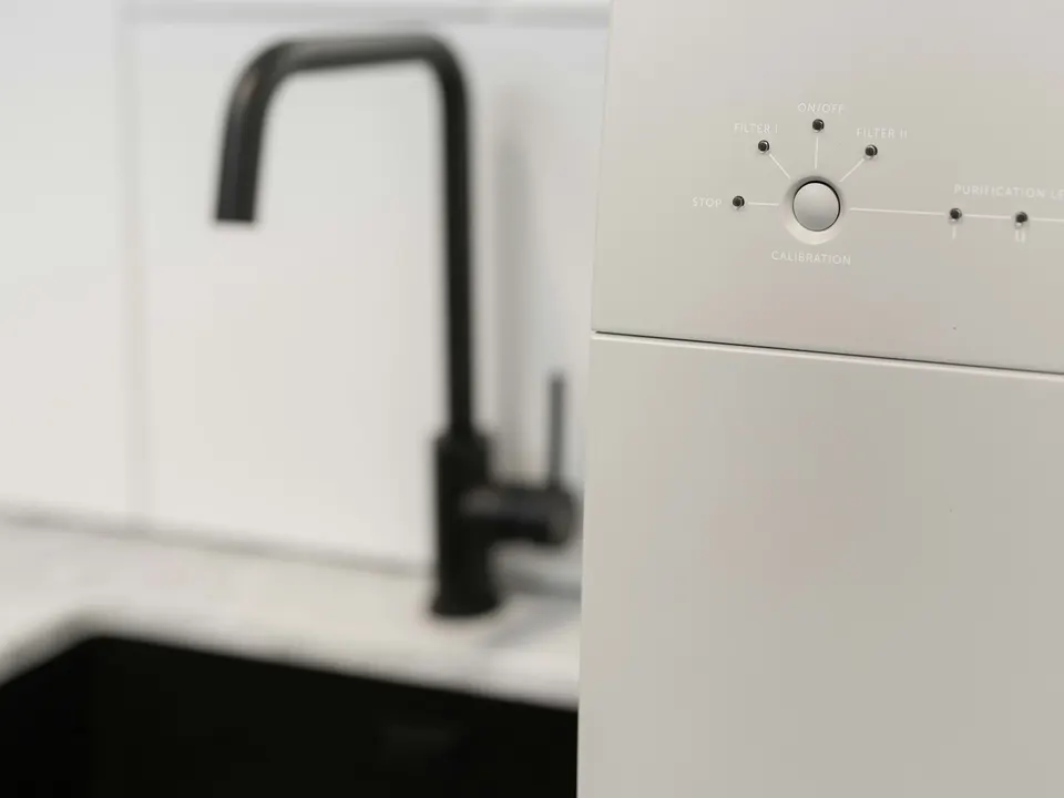Home reverse osmosis purifier beside a kitchen faucet