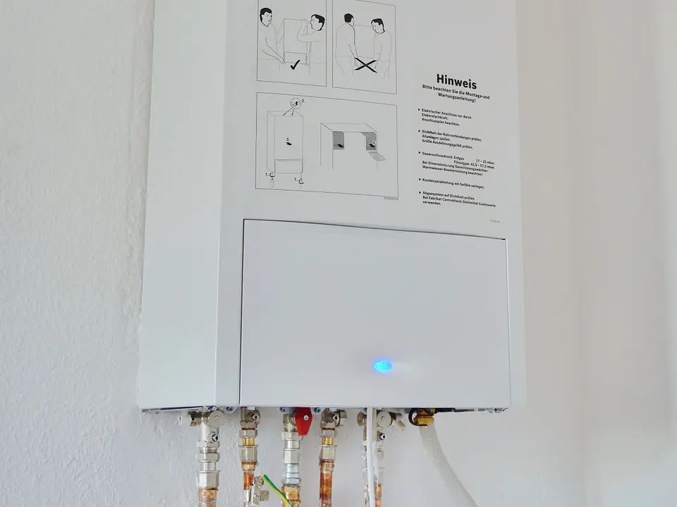 Wall-mounted tankless water heater with plumbing connections